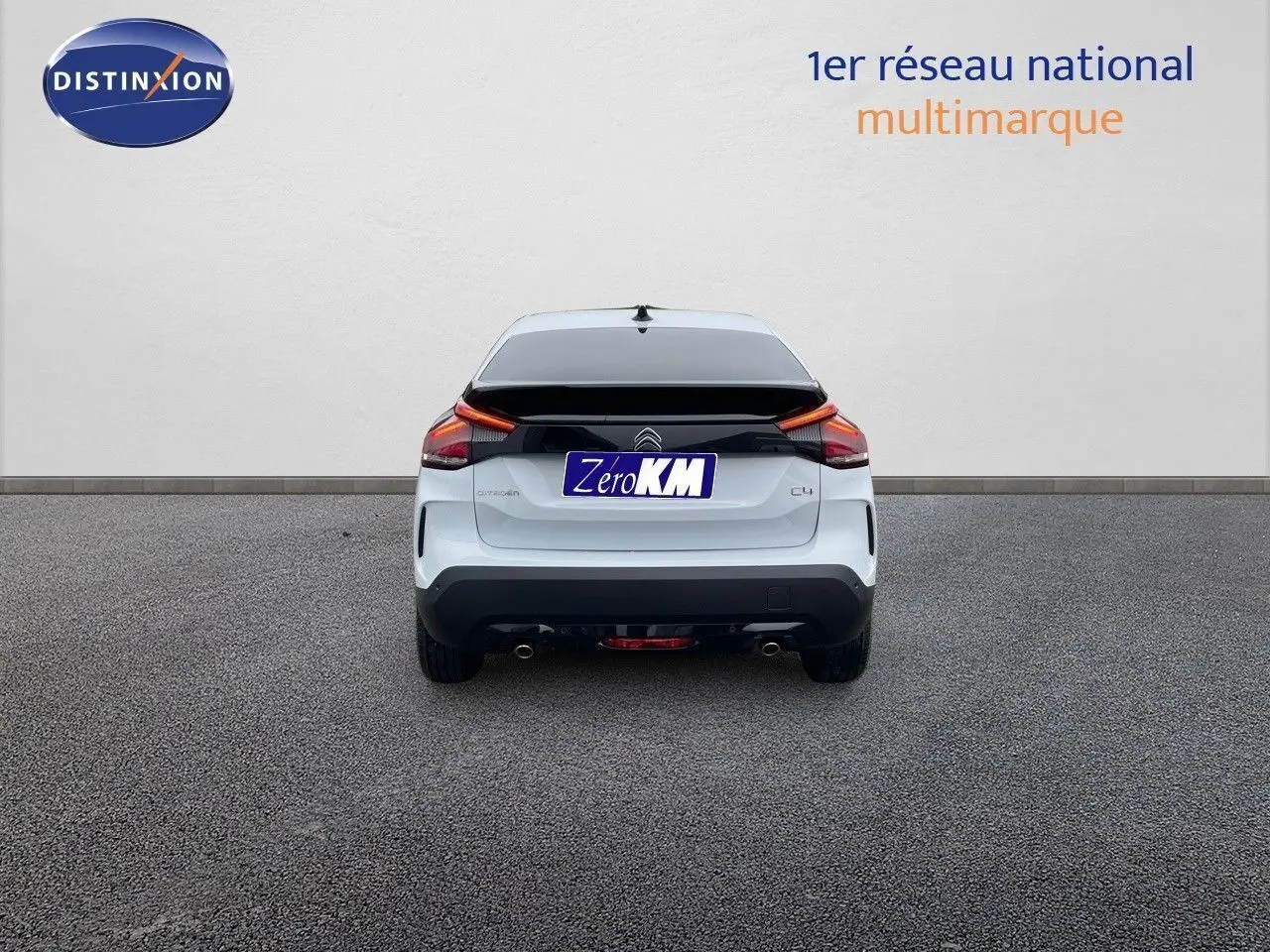 Vue arrière d'une Citroën C4 blanche métallisée 2024 avec feux arrière LED et double sortie d'échappement.