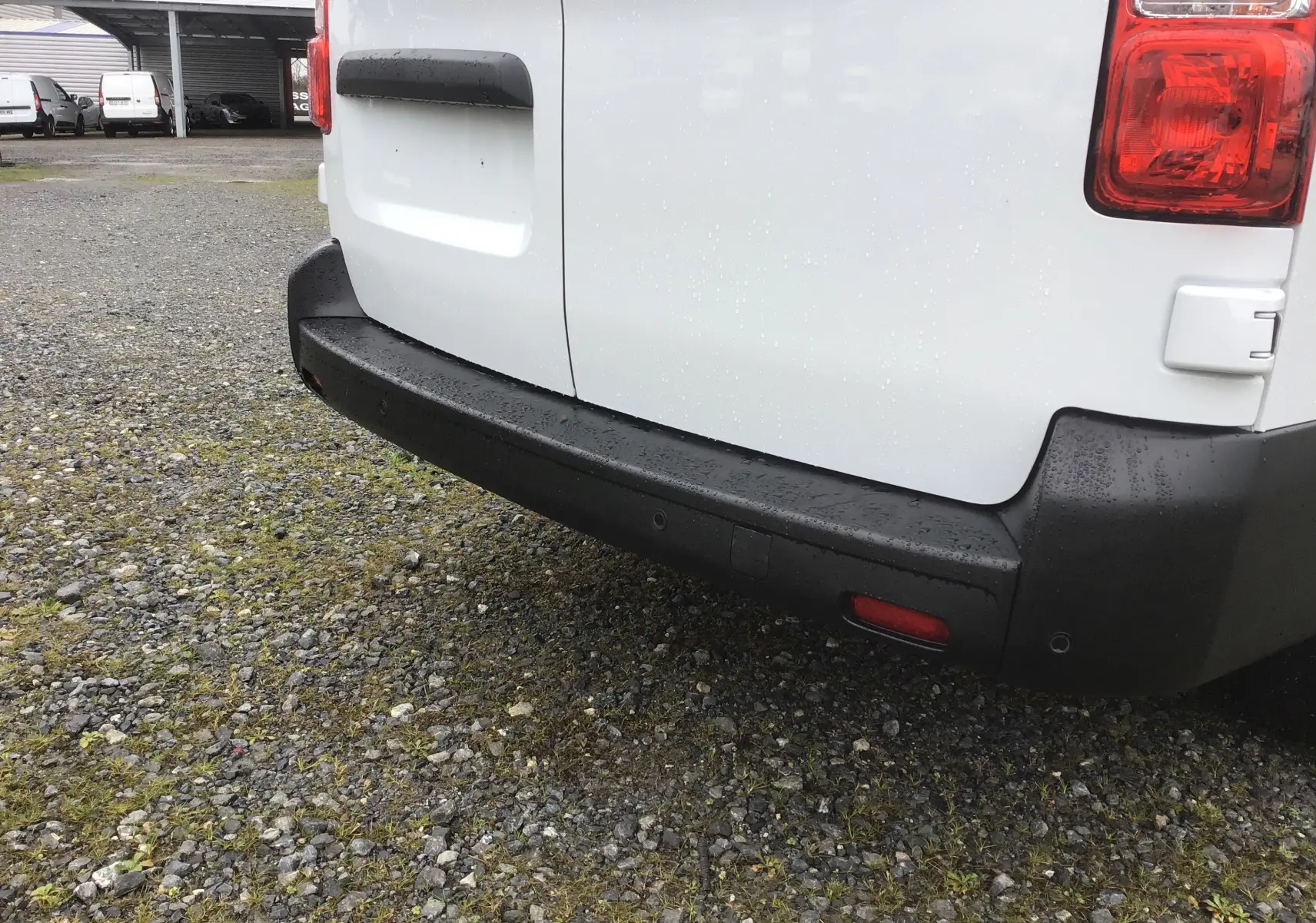 Vue rapprochée de l’arrière droit du FIAT Scudo Fourgon blanc 2024, avec pare-chocs noir et feux arrière visibles.