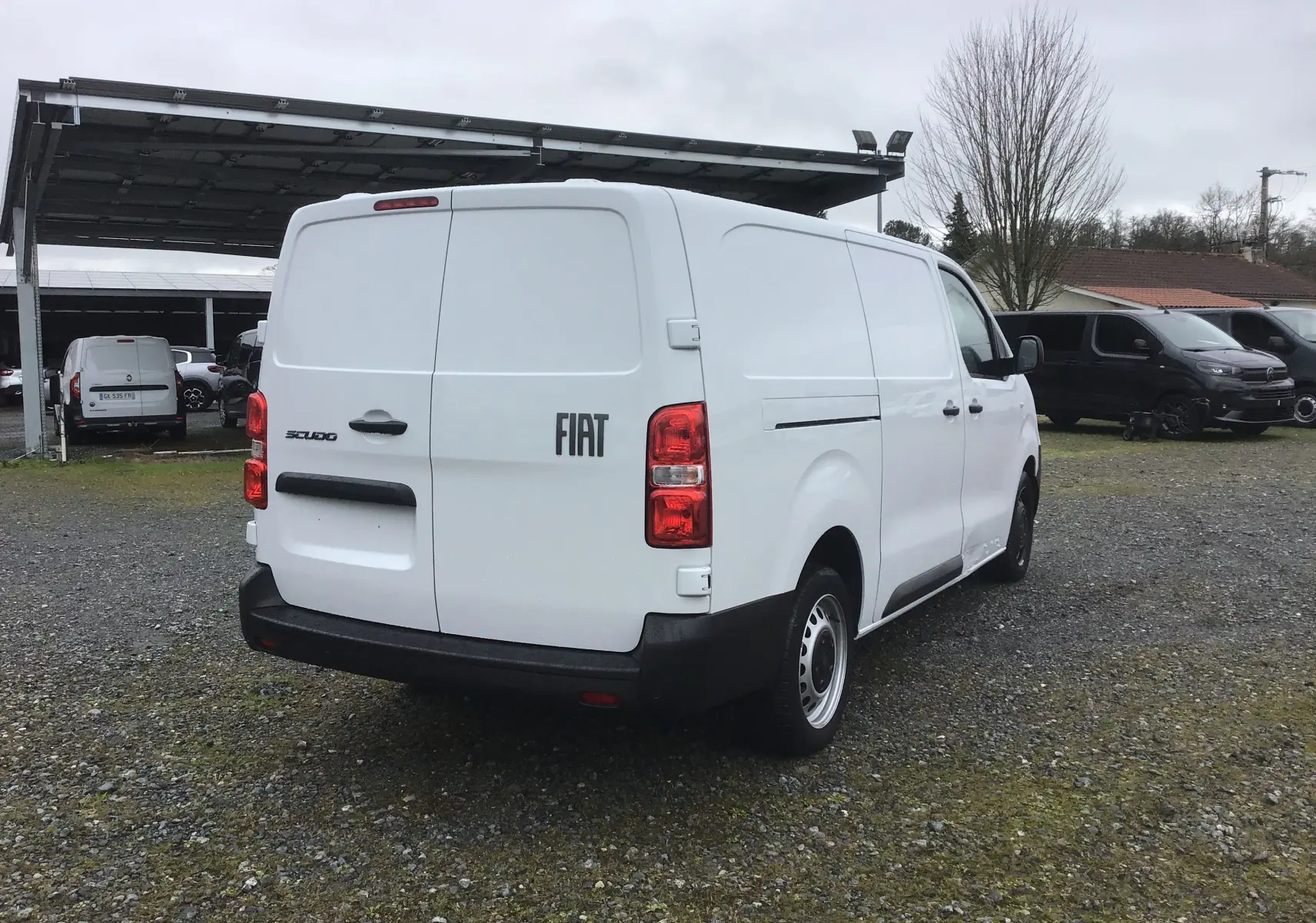 Vue 3/4 arrière droite d’un FIAT Scudo Fourgon blanc 2024 avec porte arrière pleine et pare-chocs noir.