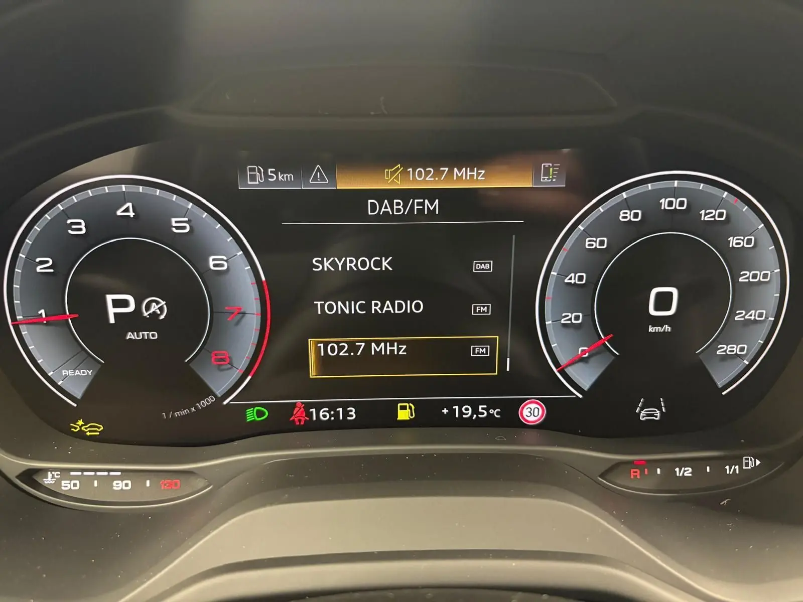 Tableau de bord numérique de l'Audi Q2 35 TFSI S Line 2026 affichant la radio et les compteurs à l'arrêt.