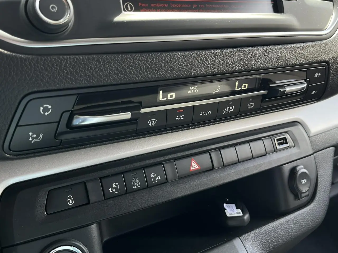Tableau de bord du Citroën Spacetourer XL noir, montrant les commandes de climatisation et les boutons de portes électriques.