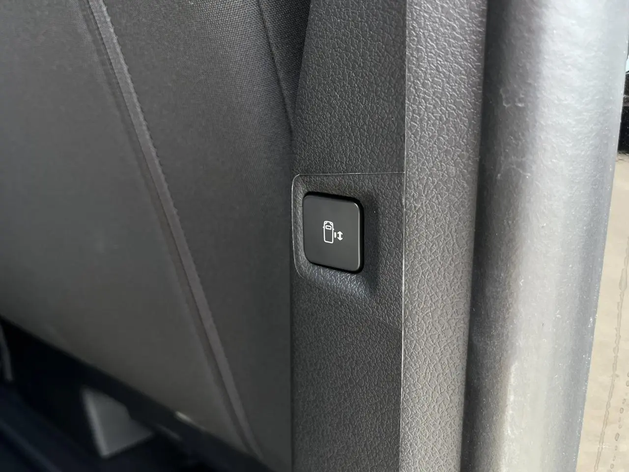 Bouton de commande de porte latérale électrique sur le côté intérieur d'un Citroën Spacetourer XL noir Perla.