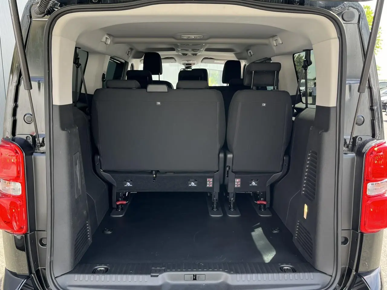 Vue arrière du Citroën Spacetourer XL noir Perla, coffre ouvert montrant les sièges arrière et l'espace de chargement.