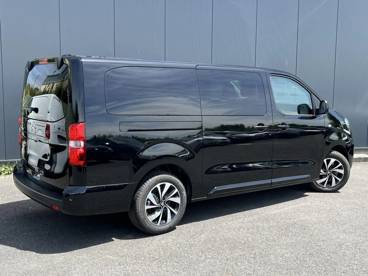 Vue 3/4 arrière droite d'un Citroën Spacetourer XL noir Perla avec jantes alu et vitres surteintées.