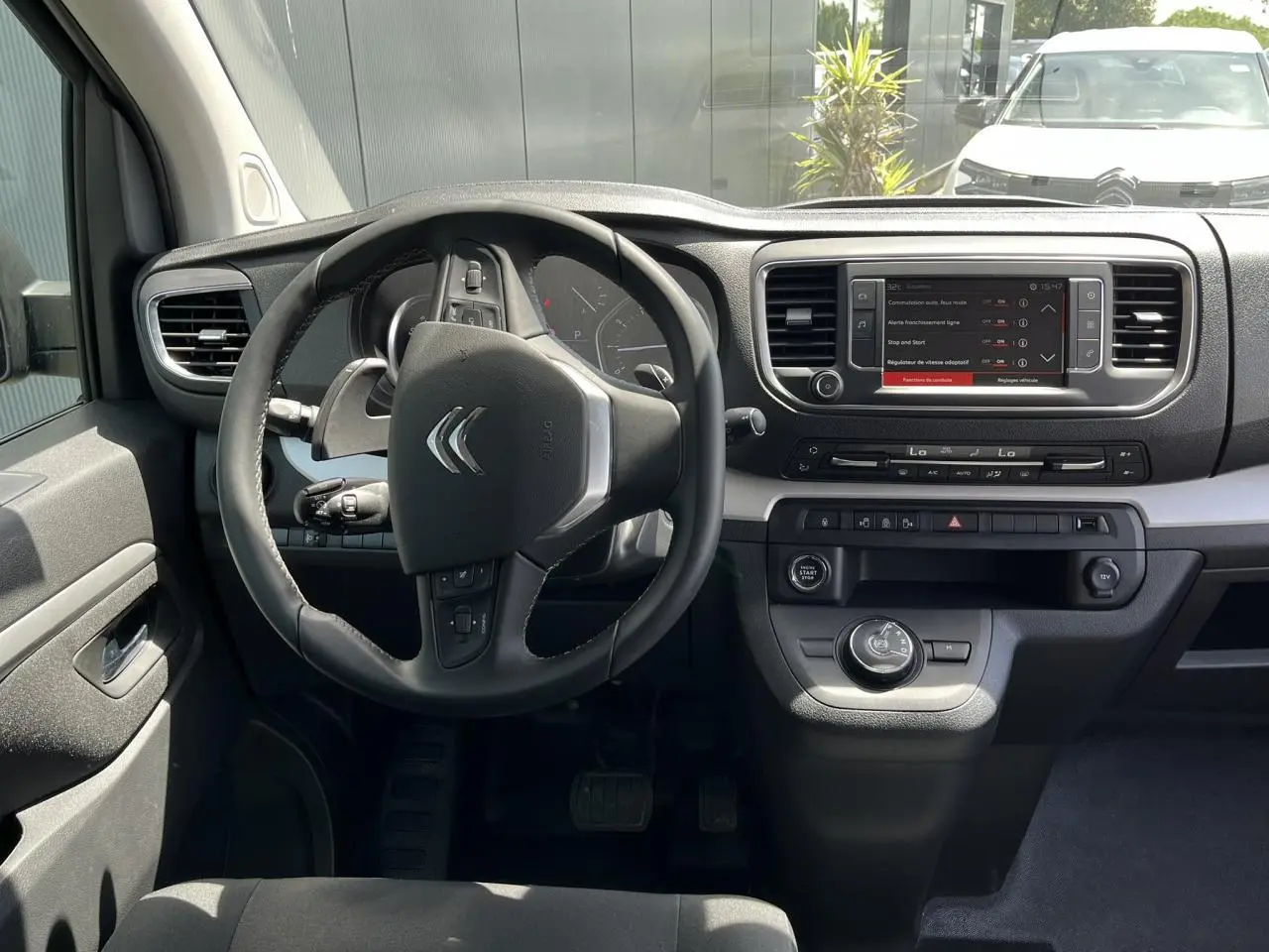 Vue intérieure du poste de conduite du Citroën Spacetourer XL noir Perla avec volant multifonction et écran tactile central.