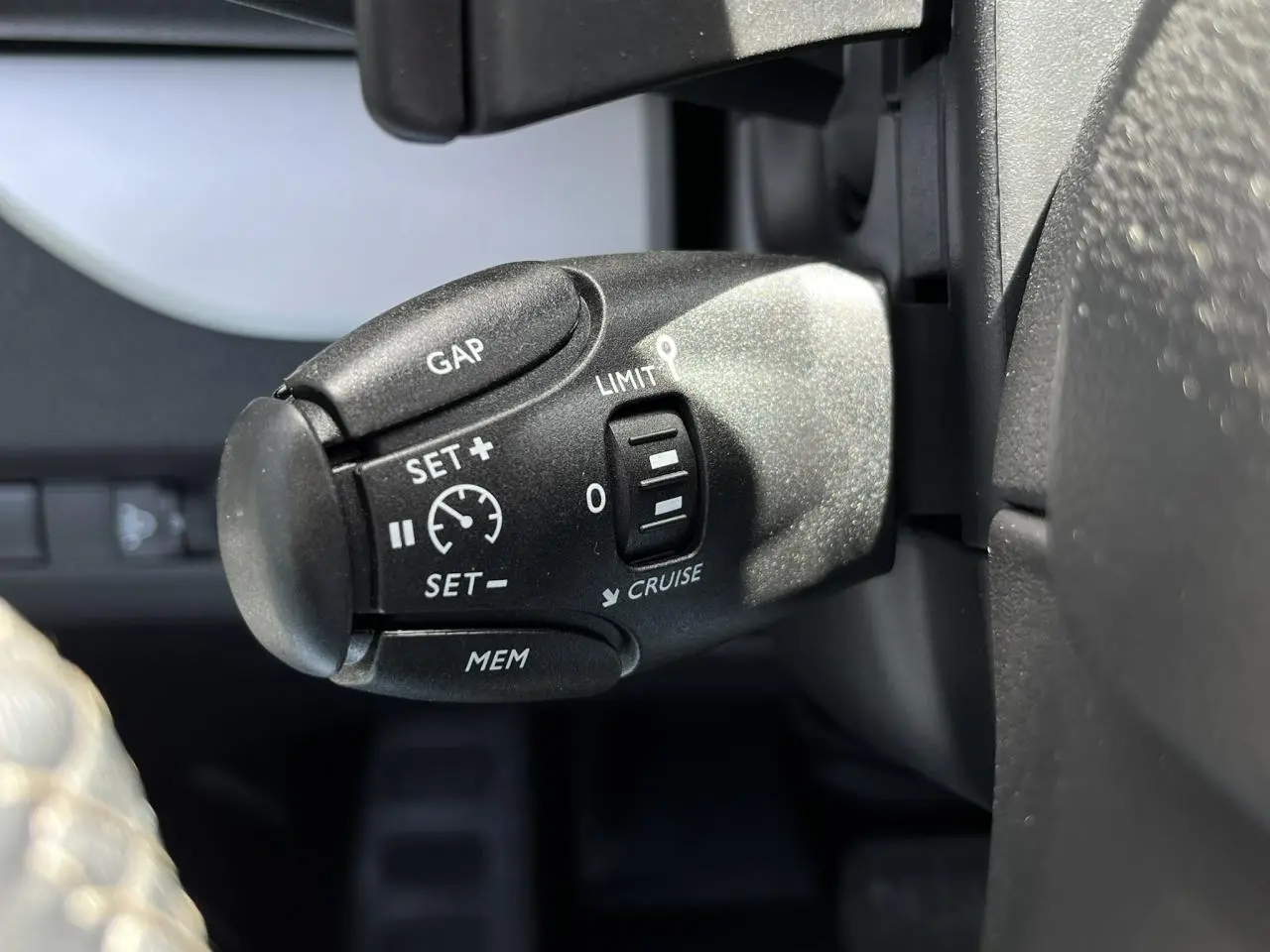 Gros plan sur la commande de régulateur de vitesse au volant du Citroën Spacetourer XL noir Perla 2024.