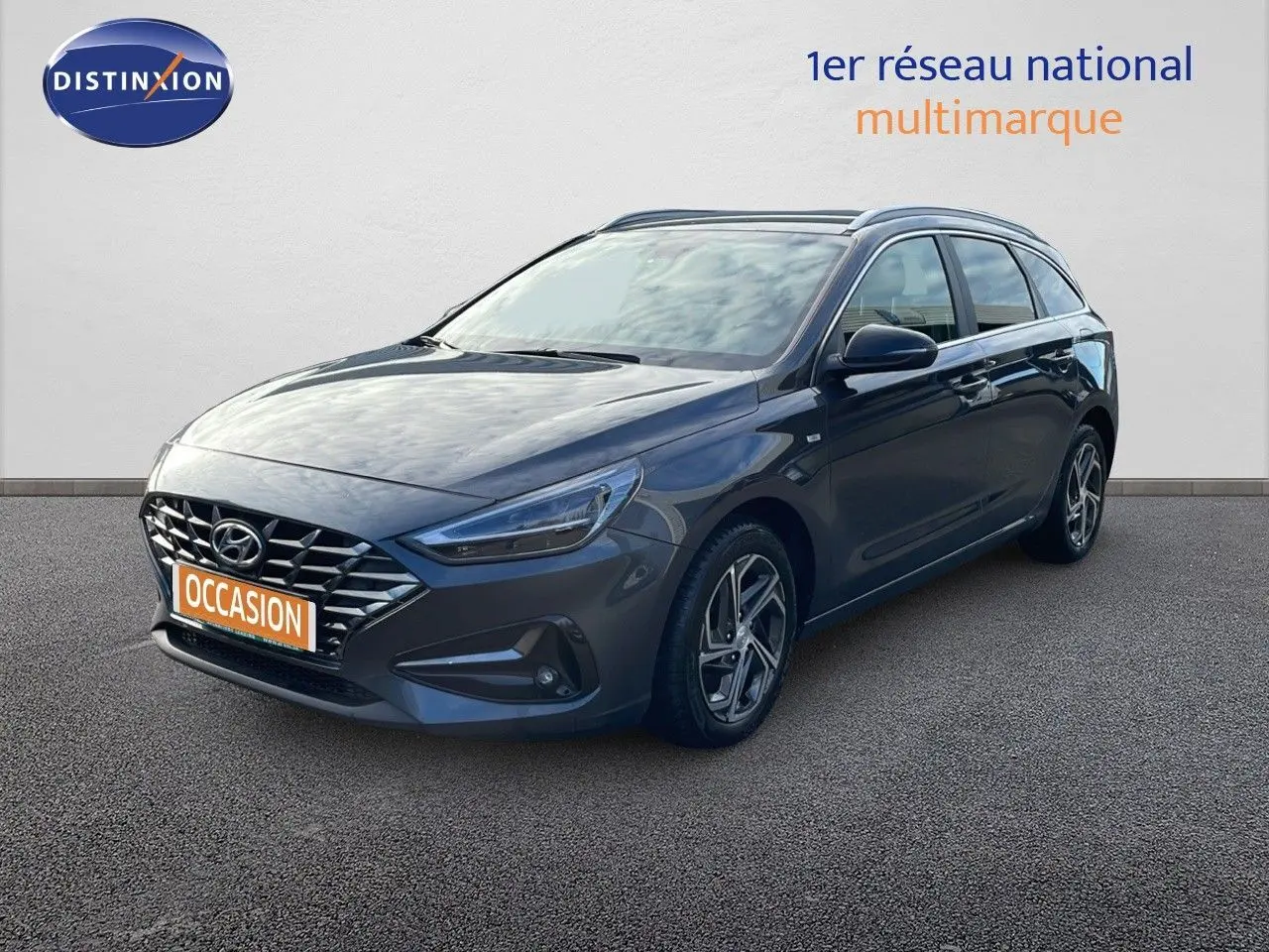 Hyundai i30 SW 2024 gris Dark Knight Metal vue 3/4 avant droit avec calandre distinctive et jantes alliage.