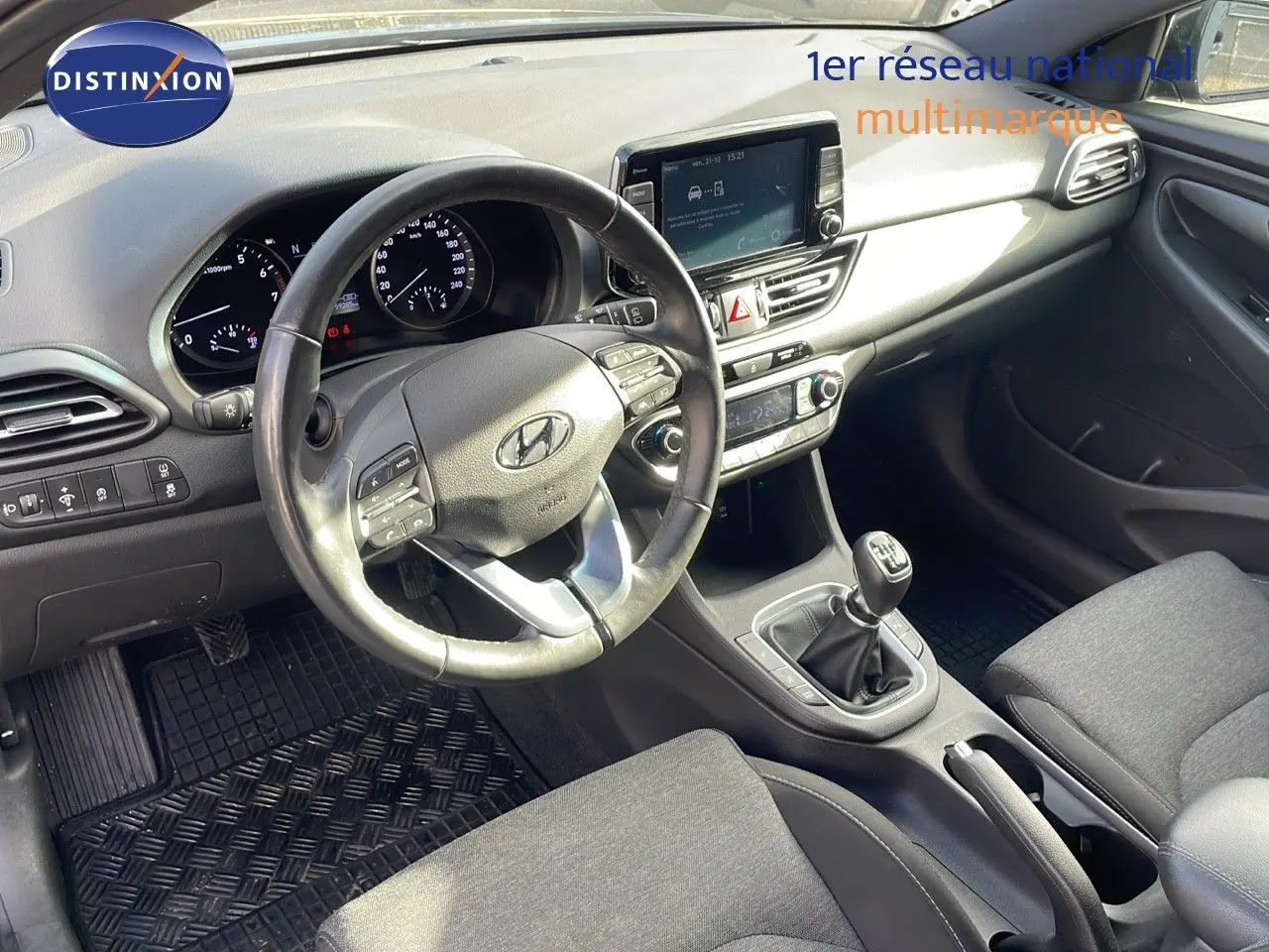 Vue intérieure côté conducteur du tableau de bord et console centrale d'une Hyundai i30 SW 2024 avec boîte manuelle.