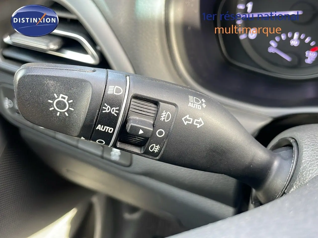 Gros plan sur la commande des feux et clignotants à gauche du volant dans l'habitacle d'une Hyundai i30 SW 2024.