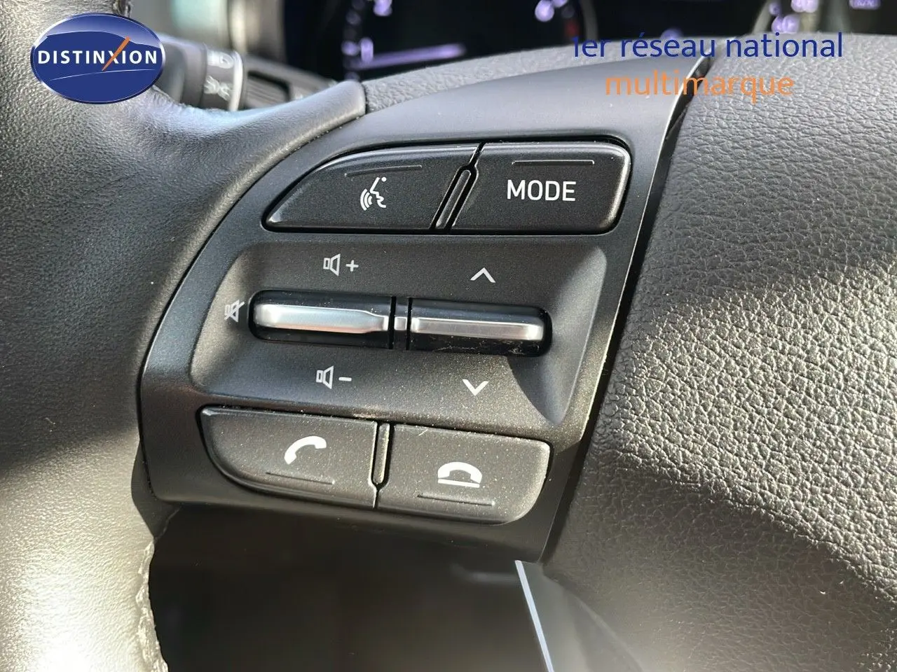 Gros plan sur les commandes audio et téléphone au volant de la Hyundai i30 SW 2024 finition Play en cuir noir.