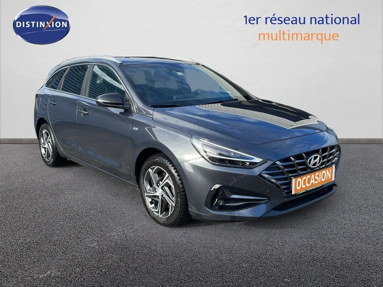 Hyundai i30 SW 2024 gris Dark Knight Metal vue 3/4 avant droit avec calandre distinctive et jantes alliage.