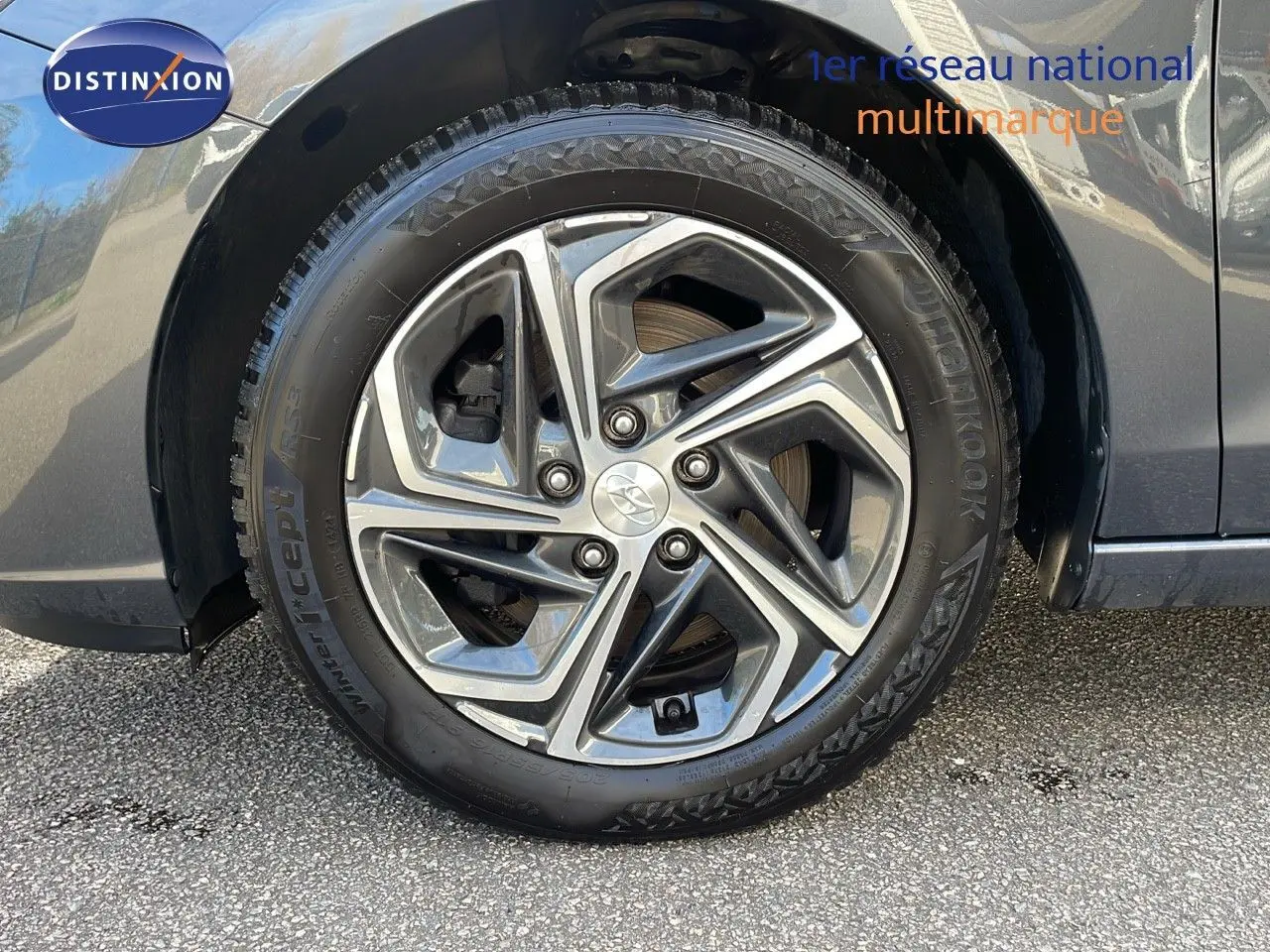 Gros plan sur la roue avant gauche de la Hyundai i30 SW 2024 en couleur Dark Knight Metal avec jante alliage moderne.