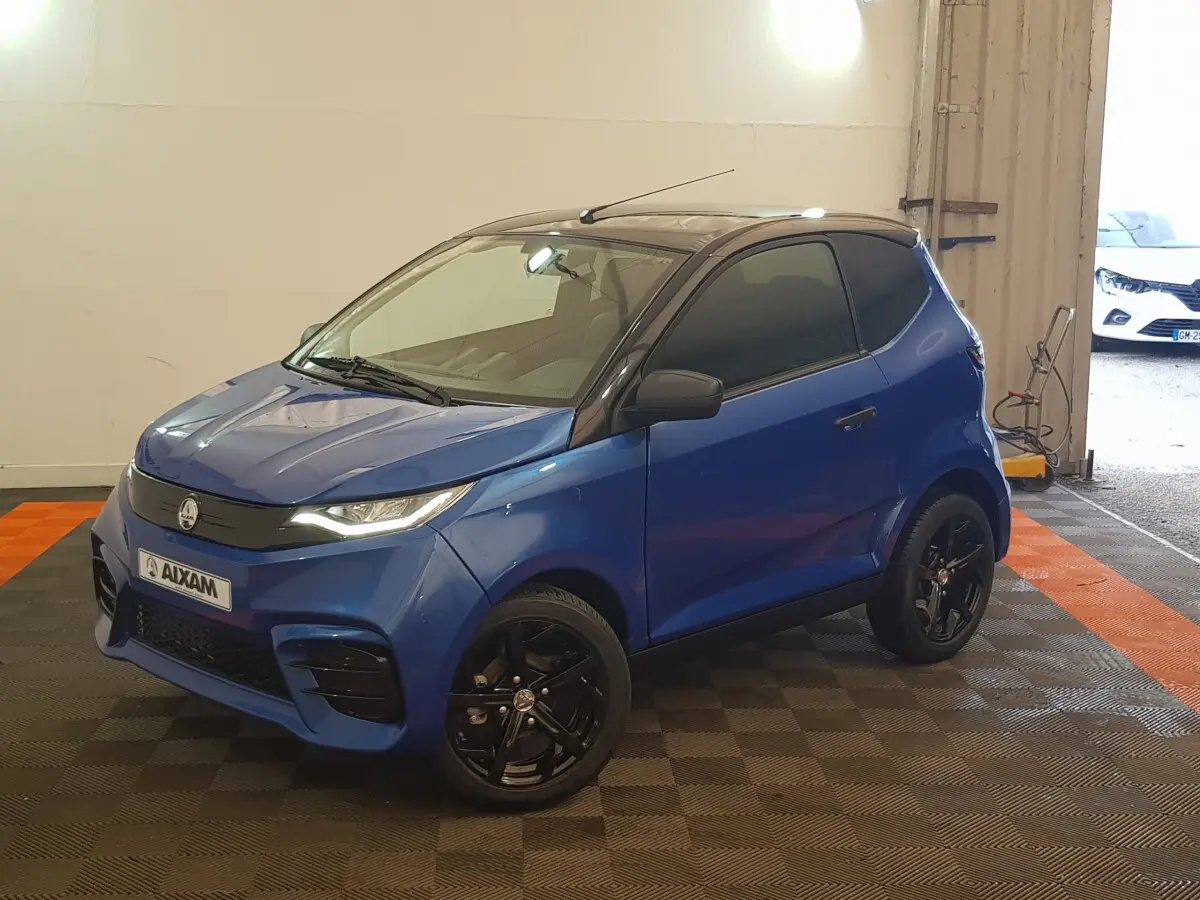 Vue 3/4 avant droite de l'AIXAM AMBITION 0.5 CITY SPORT bleu 2026 avec jantes noires et toit noir.