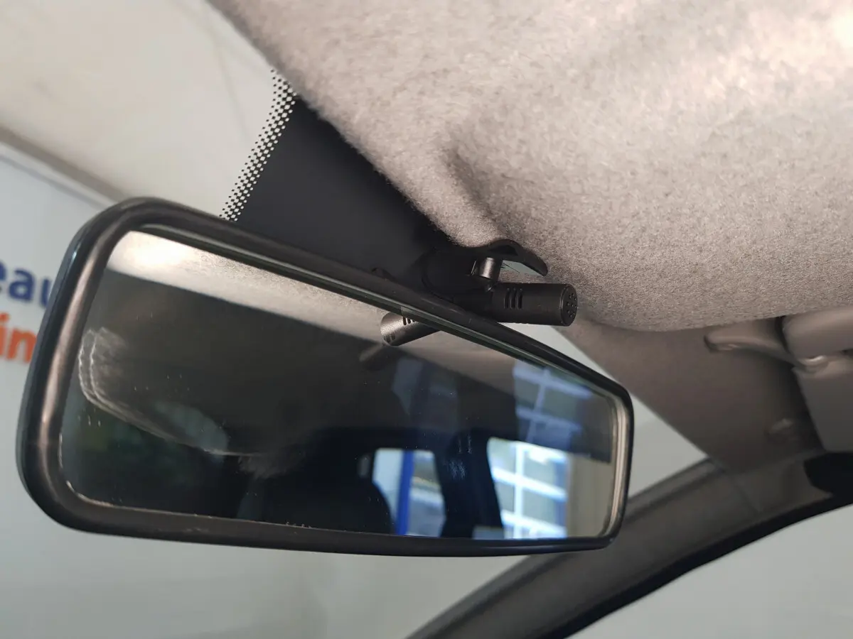 Gros plan sur la caméra intégrée au rétroviseur intérieur de l'AIXAM AMBITION 0.5 CITY SPORT bleu, côté conducteur.