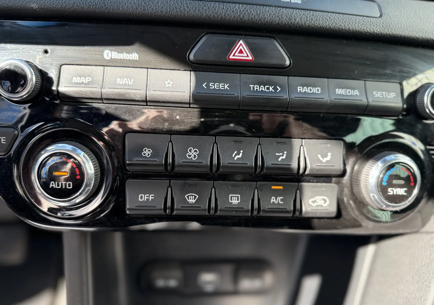 Vue rapprochée du tableau de bord du Kia Sportage 1.6 CRDI 136 Black Edition, montrant les commandes de climatisation et multimédia.