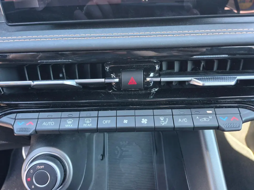 Tableau de bord de l'Alfa Romeo Tonale 2025, vue rapprochée des commandes de climatisation et ventilation noires.