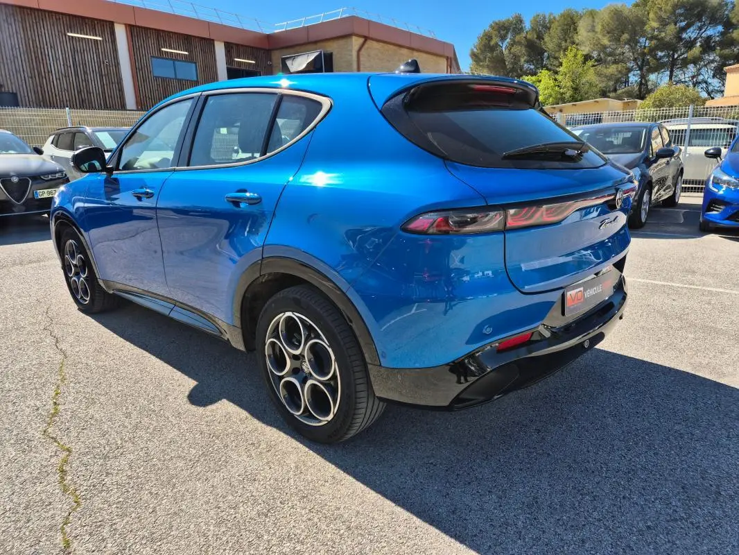 Vue 3/4 arrière droite d'une Alfa Romeo Tonale bleu 2025 avec jantes alliage 18 pouces et feux arrière fins.