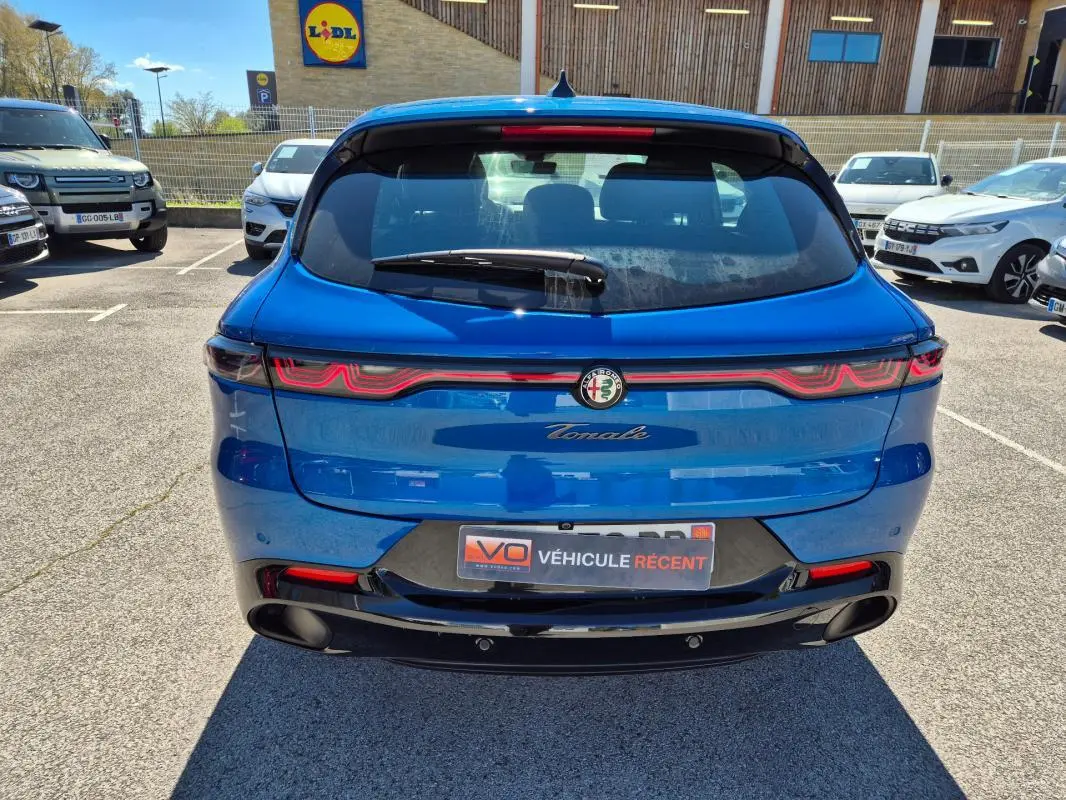 Vue arrière d'une Alfa Romeo Tonale bleu 2025 avec feux arrière LED et double sortie d'échappement noire.