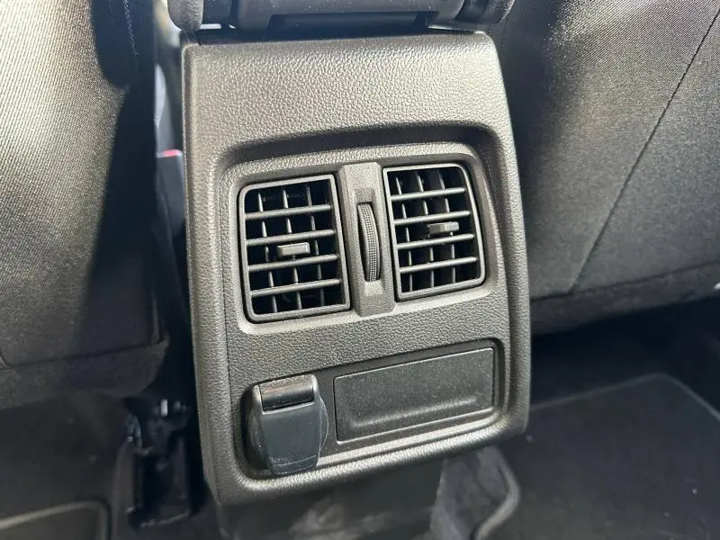 Détail des aérateurs arrière et prise 12V noirs dans l'habitacle du Renault Captur blanc nacré 2025.