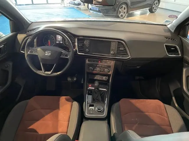 Vue intérieure avant du SEAT Ateca 2017 avec tableau de bord noir et sièges bicolores marron et noir.