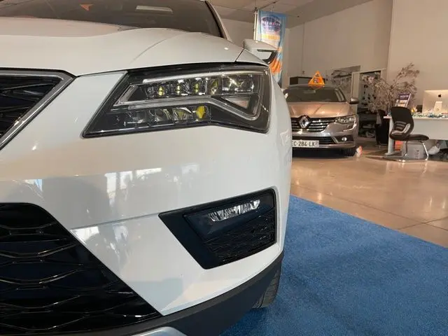 Gros plan sur l'avant droit blanc Nevada du SEAT Ateca 2017, mettant en valeur ses phares LED et la calandre noire.