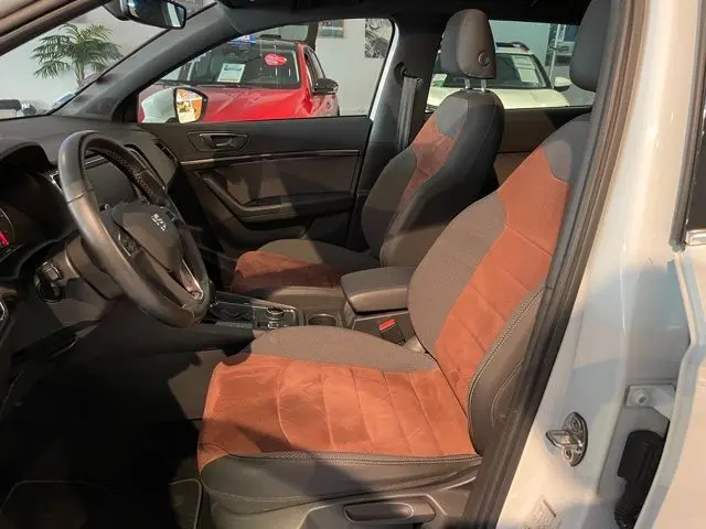 Intérieur du SEAT Ateca blanc Nevada 2017 vu côté conducteur, sièges tissu noir et brun, tableau de bord moderne.