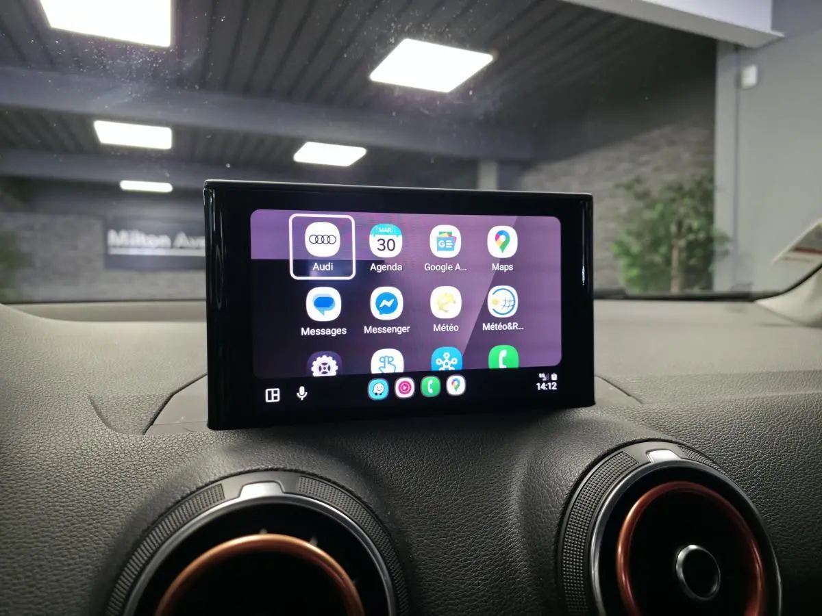 Écran tactile MMI central affichant applications connectées, entouré de buses d'aération avec cerclage rouge dans Audi Q2 noir 2017.