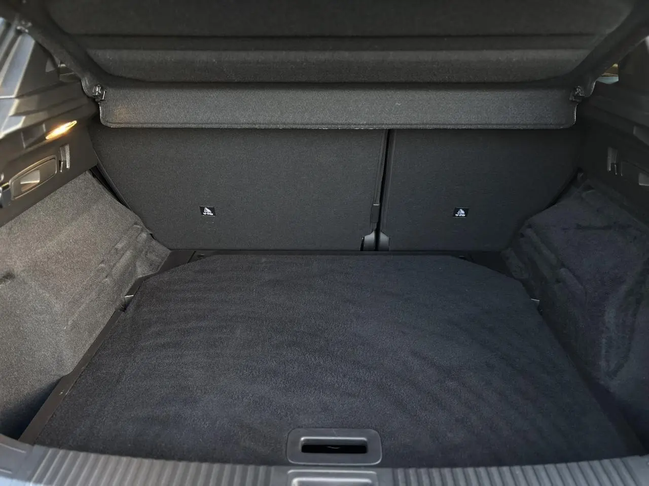 Coffre spacieux vu de l'arrière du Renault Austral 1.3 TCE MHEV 160 Iconic noir étoilé avec habillage intérieur noir.