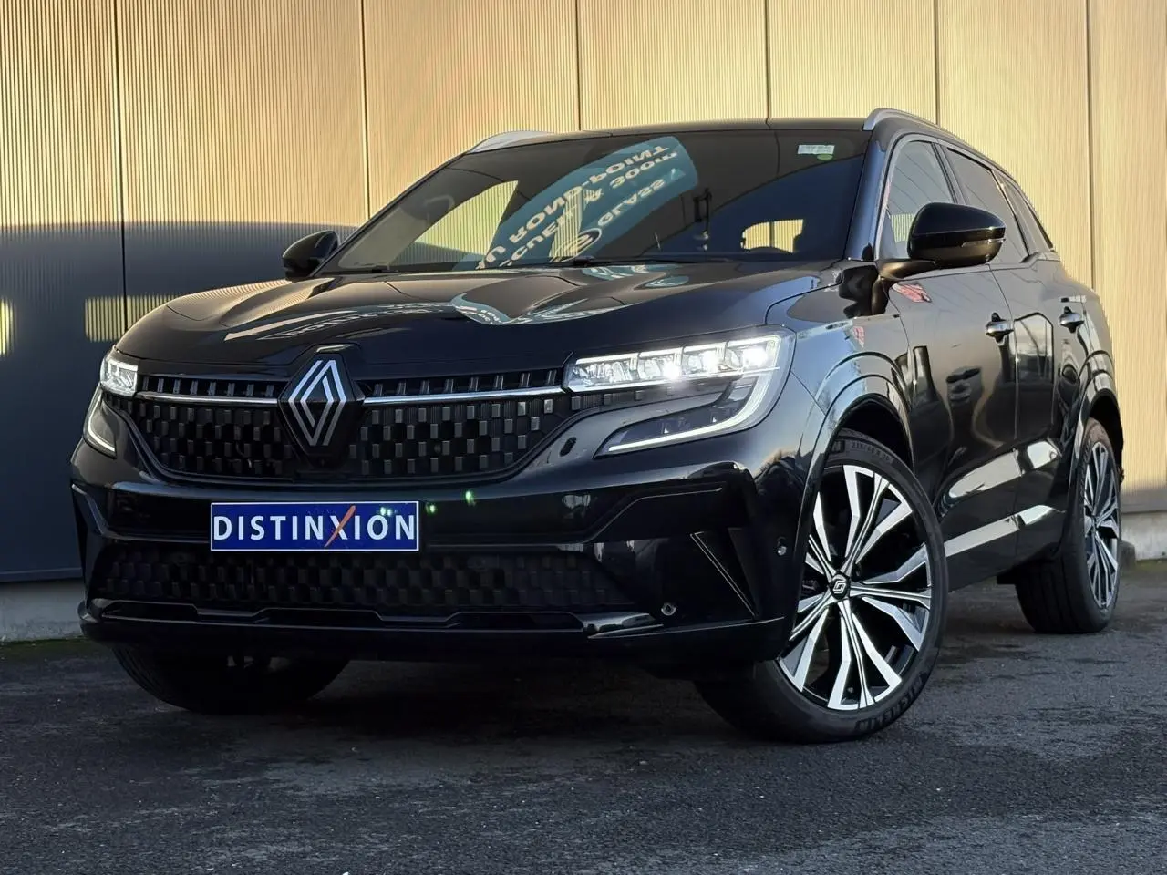 Renault Austral noir étoile vu en 3/4 avant droit avec calandre damier et jantes alliage 20 pouces.
