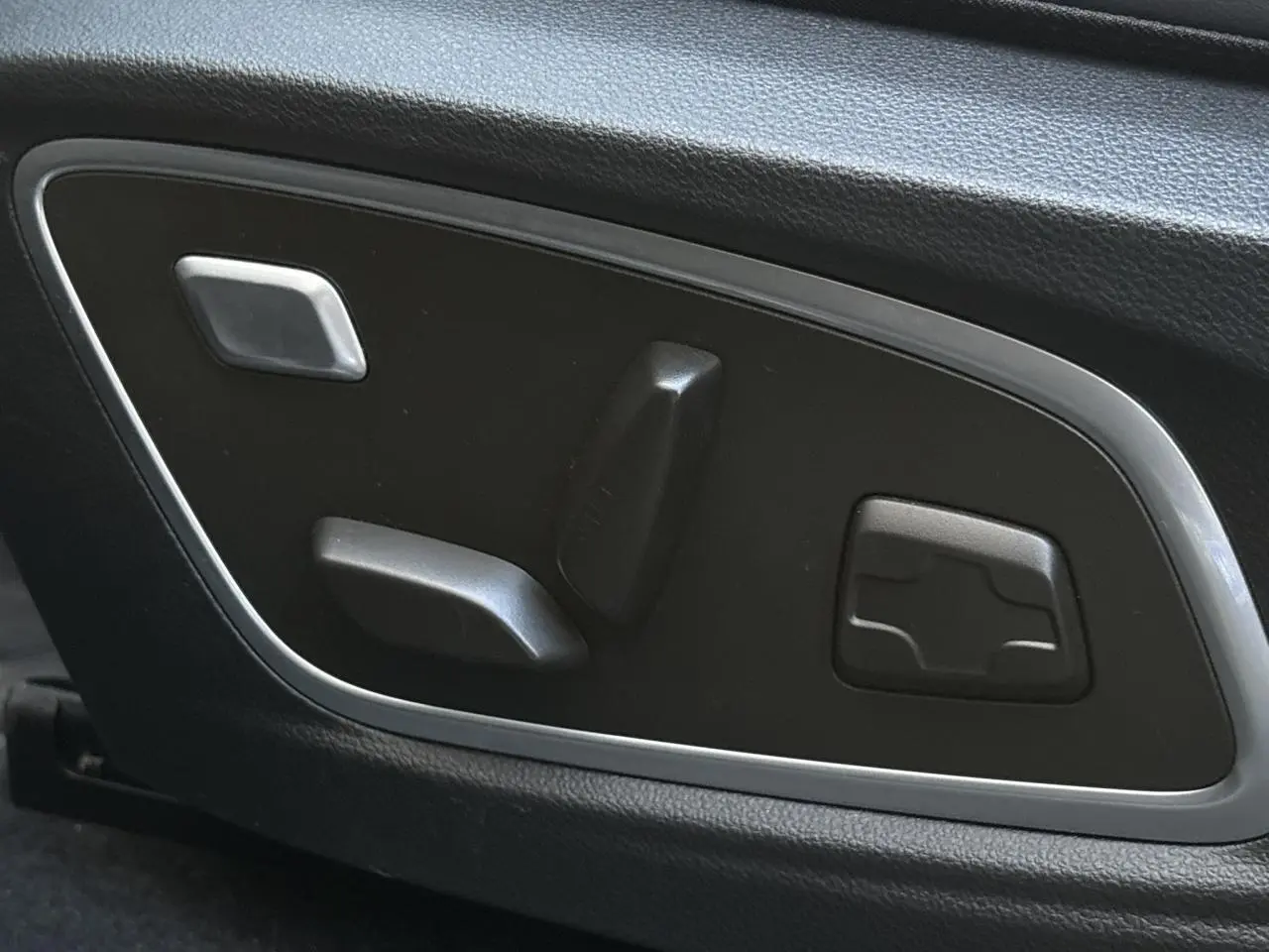 Commandes électriques des réglages du siège conducteur sur la porte intérieure d'un Renault Austral noir étoile 2023.