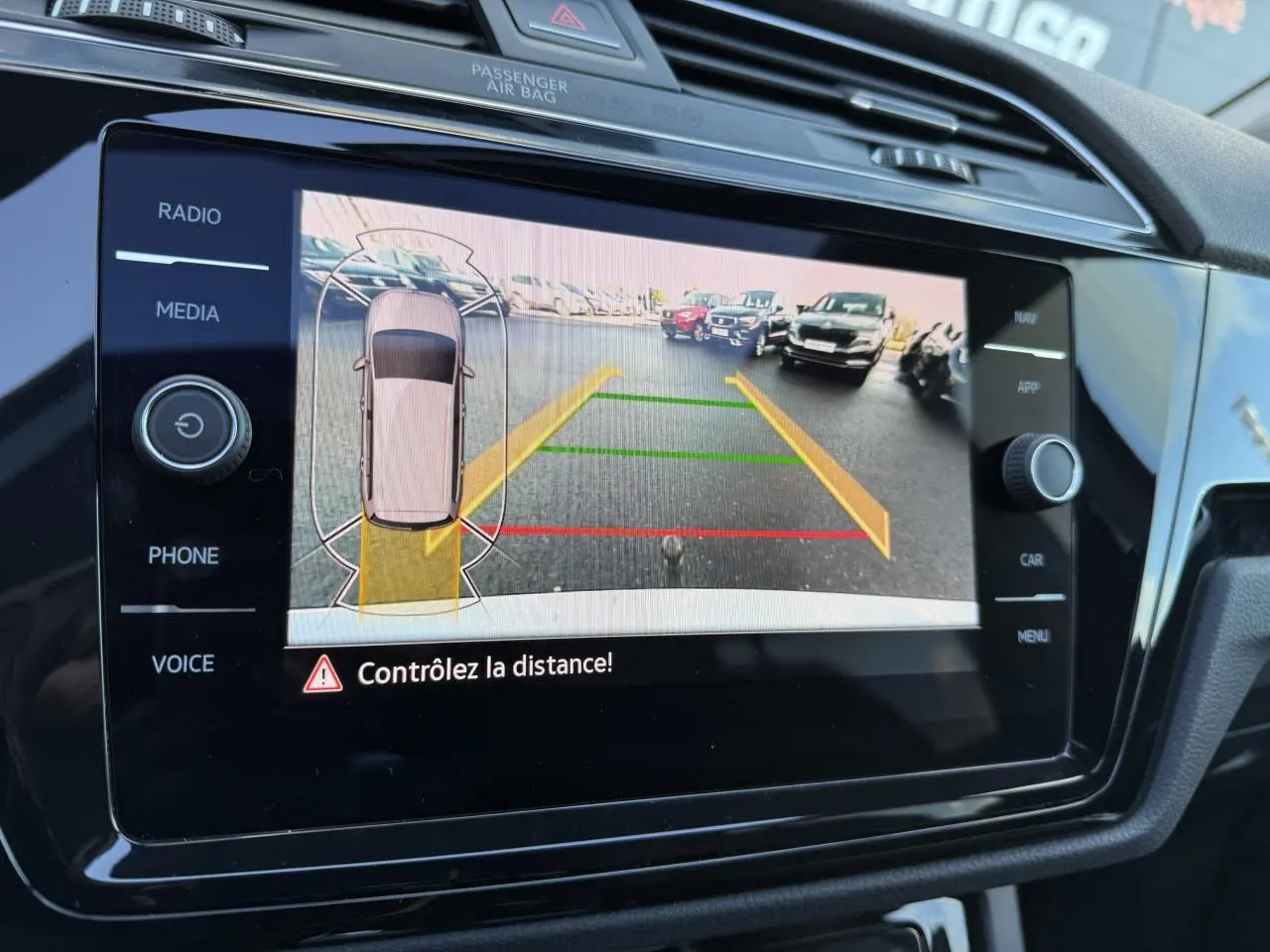 Écran tactile intérieur montrant la caméra de recul et l'aide au stationnement du Volkswagen Touran argent Dolomite 2025.