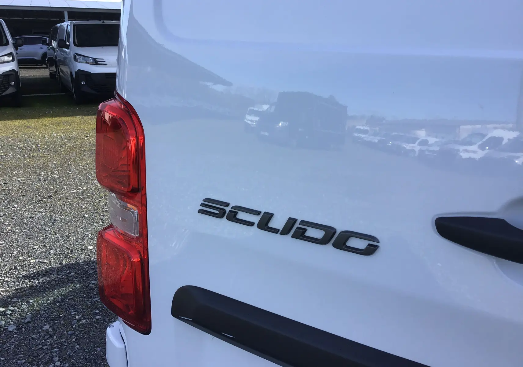 Gros plan sur l'arrière gauche blanc du FIAT Scudo Fourgon 2024 avec feu rouge et logo Scudo visible.