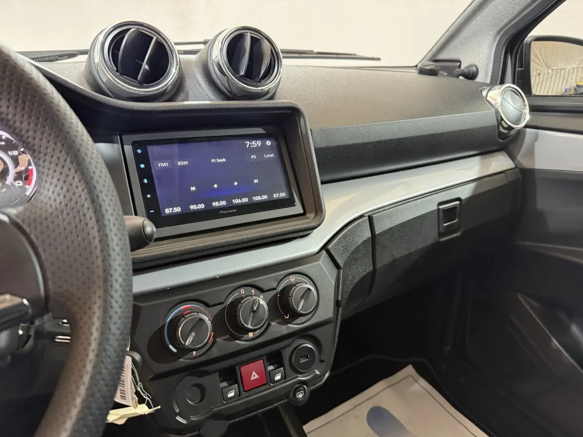 Vue intérieure de la planche de bord de l'AIXAM Ambition 0.5 Crossover Premium avec écran tactile et commandes manuelles.