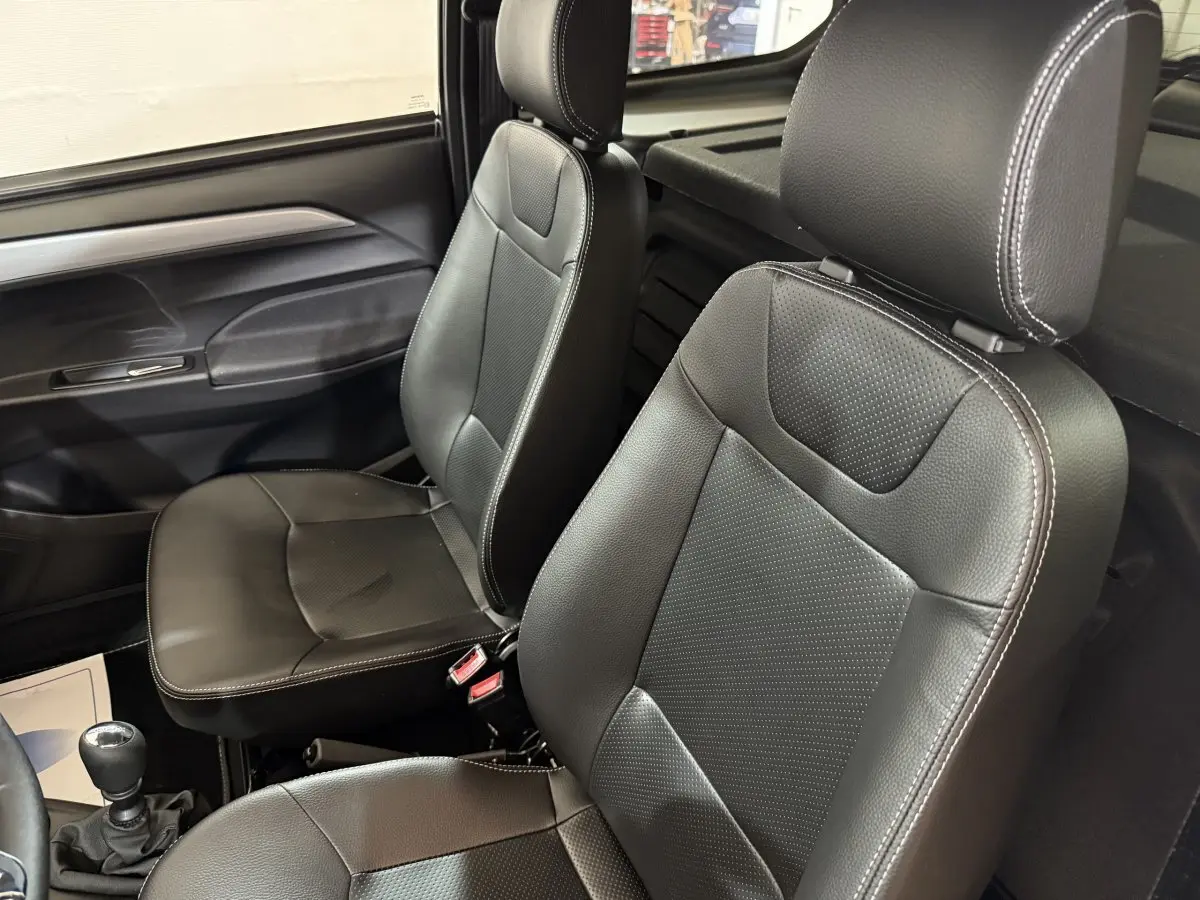 Vue intérieure rapprochée des sièges avant en cuir noir de l'AIXAM AMBITION 0.5 CROSSOVER PREMIUM 2026.