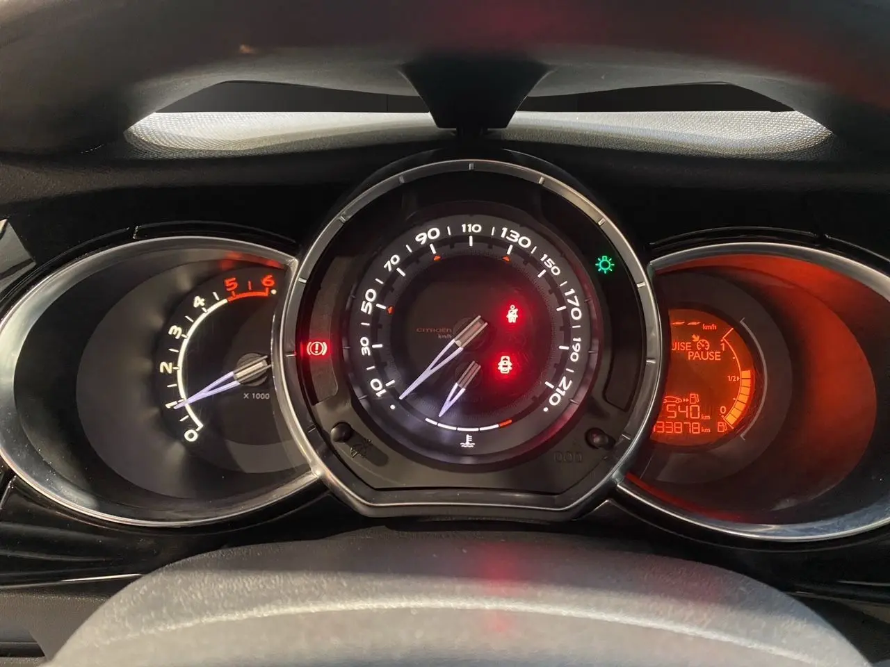 Vue rapprochée du tableau de bord de la Citroën DS3 1.6 E-HDI, avec compte-tours, compteur et affichage digital rouge.