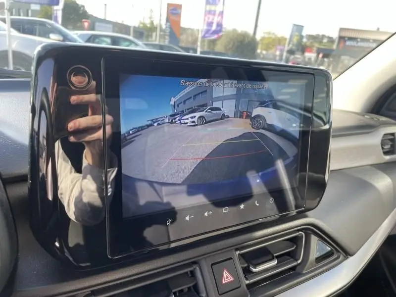 Écran central affichant la caméra de recul d'une Suzuki Swift 1.2 Dualjet Hybrid bleu métal, vue intérieure du tableau de bord.