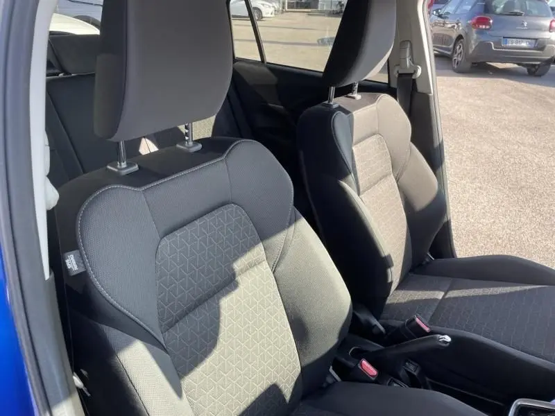 Vue intérieure côté gauche des sièges avant en tissu gris de la Suzuki Swift 1.2 Dualjet Hybrid 2024 bleu métal.