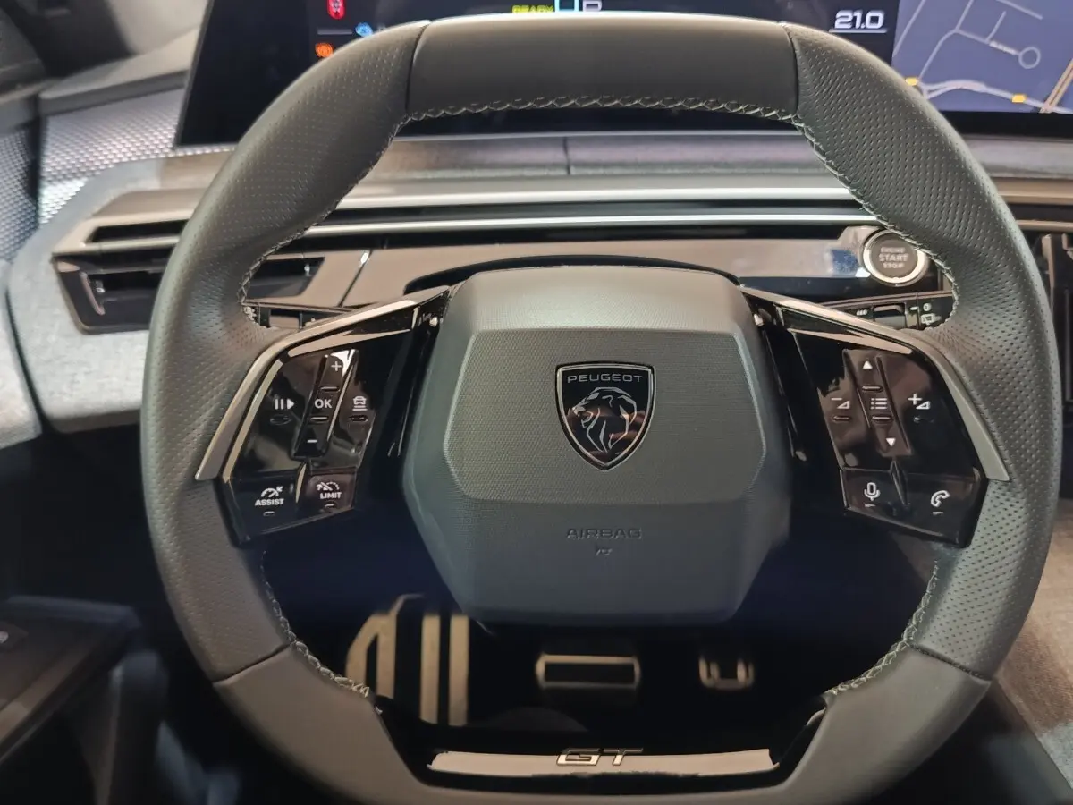 Volant cuir noir de Peugeot 5008 1.6 PHEV GT 2026 vu de face avec commandes multifonctions et bouton démarrage.