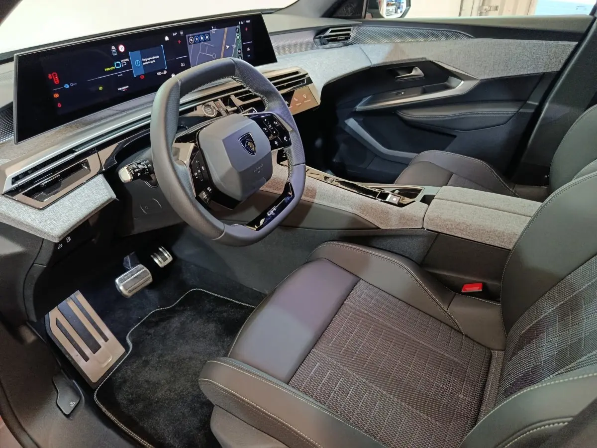 Vue intérieure côté conducteur du Peugeot 5008 1.6 PHEV 195 E-DCS7 GT 2026, tableau de bord numérique et volant cuir.