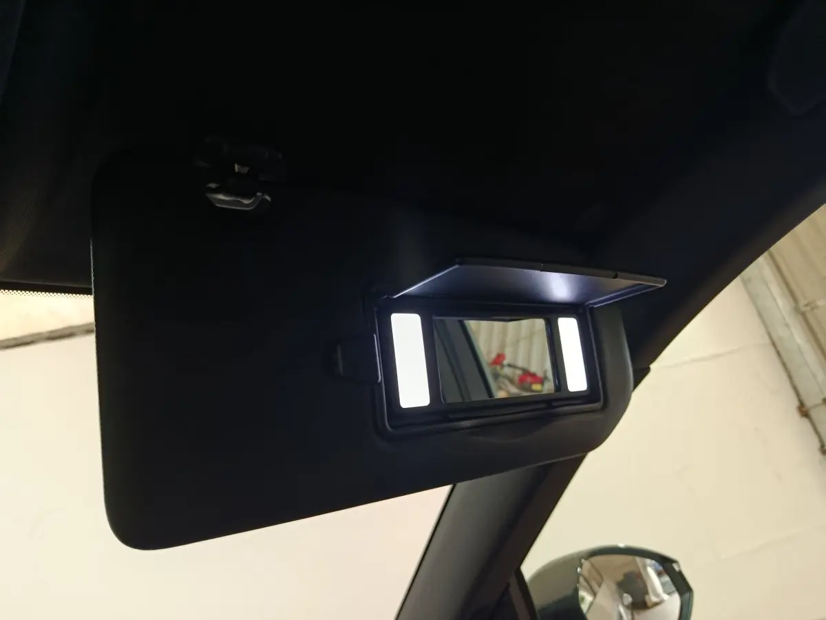 Détail du pare-soleil intérieur noir avec miroir éclairé dans un Peugeot 5008 gris clair, vue côté passager.