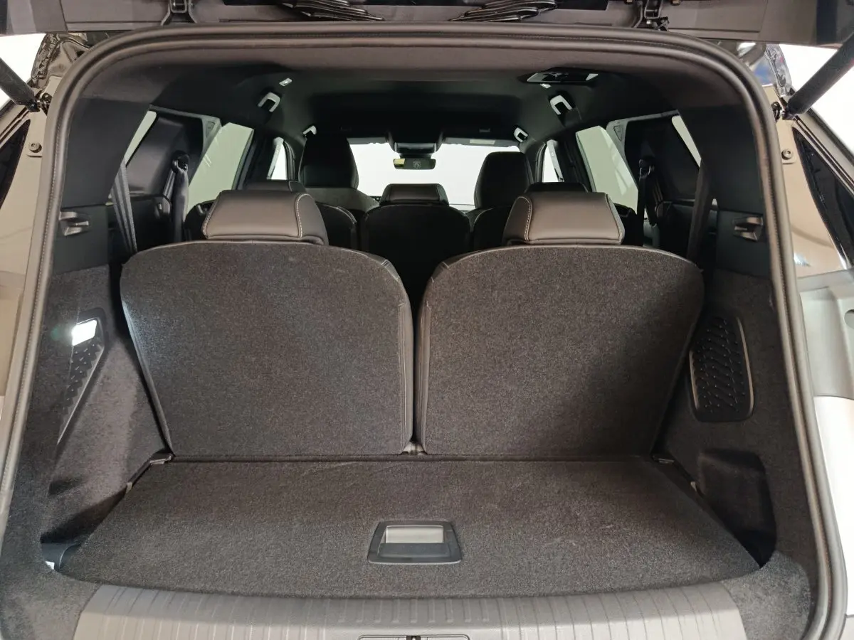 Coffre ouvert vue arrière du Peugeot 5008 gris clair avec sièges de troisième rangée relevés.