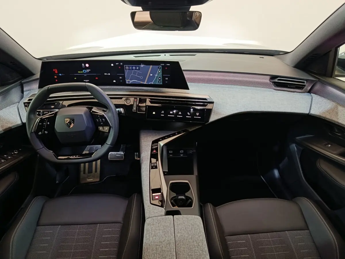 Vue intérieure avant du Peugeot 5008 2026 hybride rechargeable, tableau de bord moderne avec grand écran tactile panoramique.