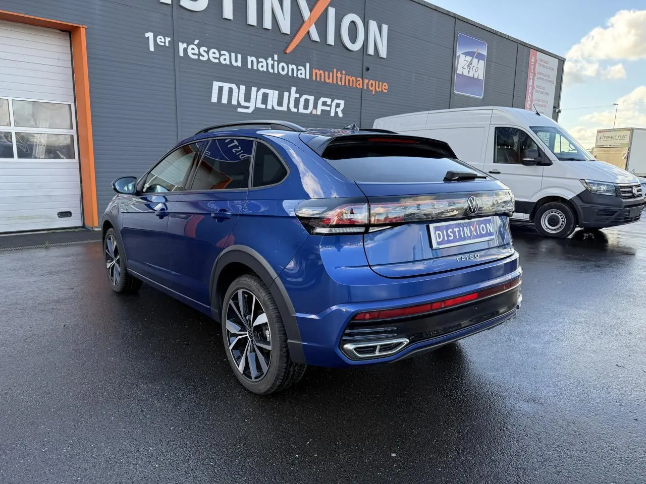 Volkswagen Taigo bleu récif métallisé en 3/4 arrière droit, avec jantes noires brillantes et feux arrière LED.