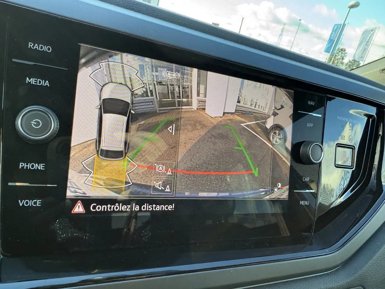 Écran de caméra de recul du Volkswagen Taigo 2025 montrant l'aide au stationnement arrière en extérieur.