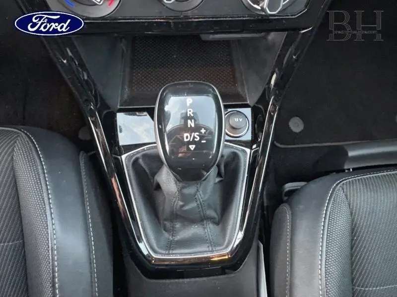 Le levier de vitesses automatique noir brillant du Volkswagen T-Cross 1.0 TSI 110ch Lounge Business vu de dessus entre les sièges avant.