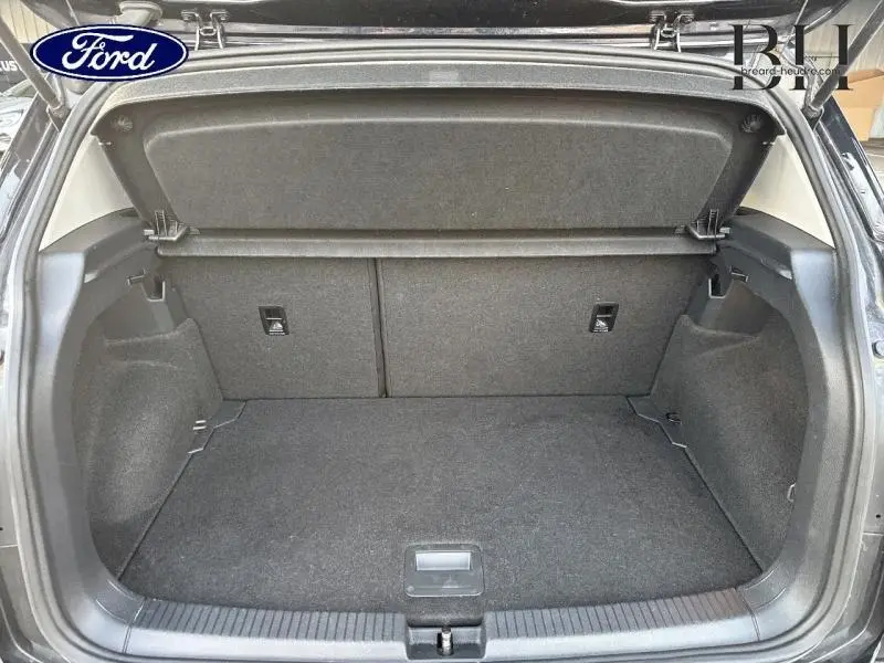 Coffre ouvert du Volkswagen T-Cross noir intense nacré, montrant un espace de chargement propre et spacieux.