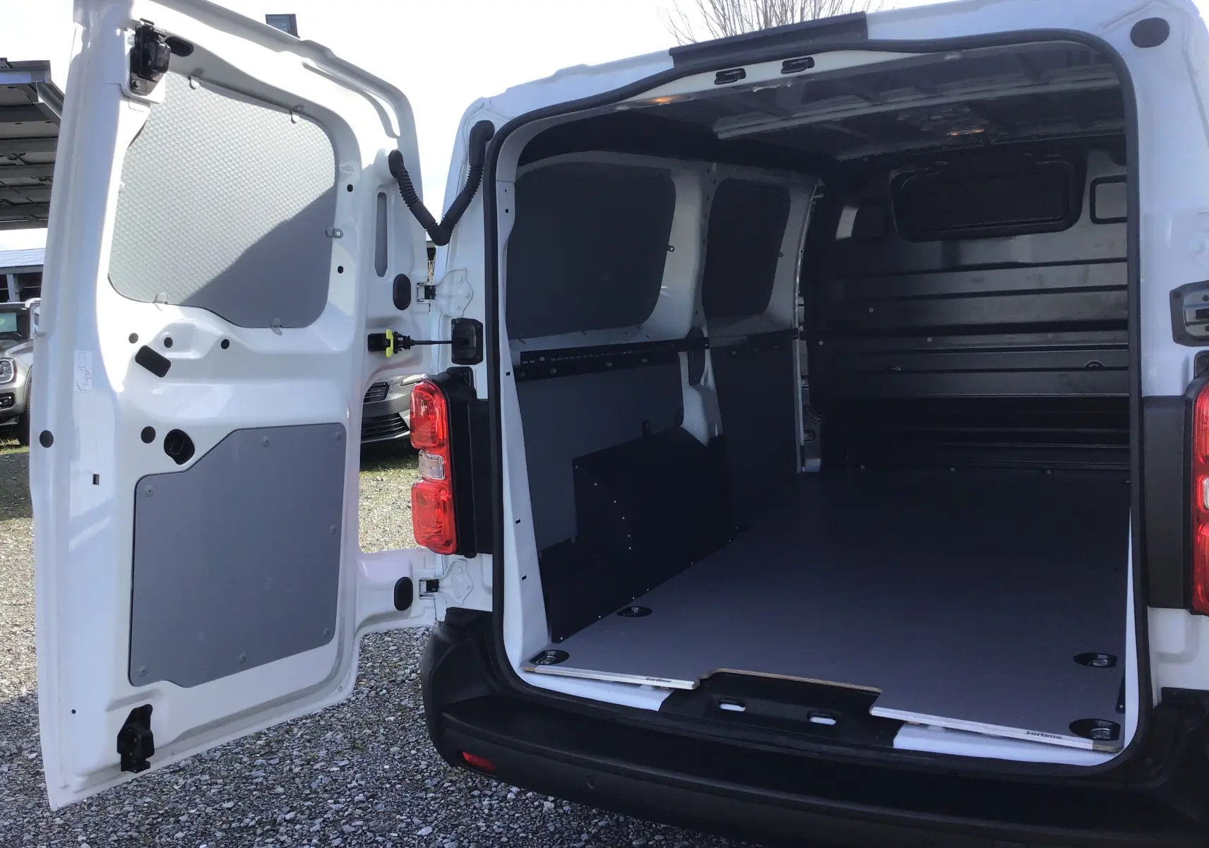 Vue arrière du FIAT Scudo Fourgon blanc 2024 avec portes ouvertes montrant l’espace de chargement vide et protégé.