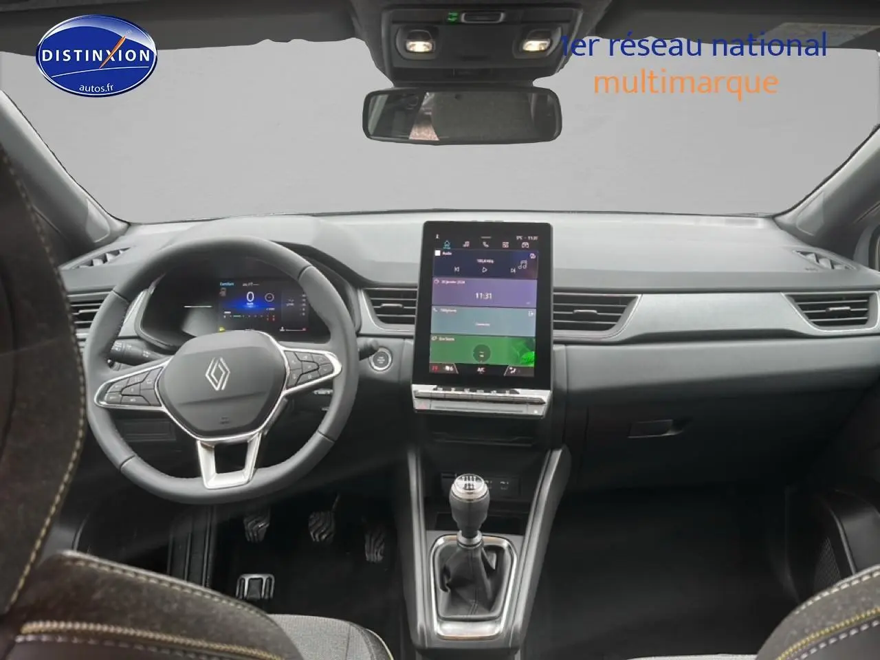 Vue intérieure avant du Renault Captur gris rafale 2025, avec volant multifonction et écran tactile vertical.