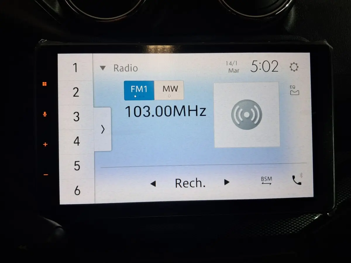Écran tactile de la radio affichant la fréquence 103.00 MHz dans l'habitacle d'une Aixam Ambition 0.5 City Coupe GTI.