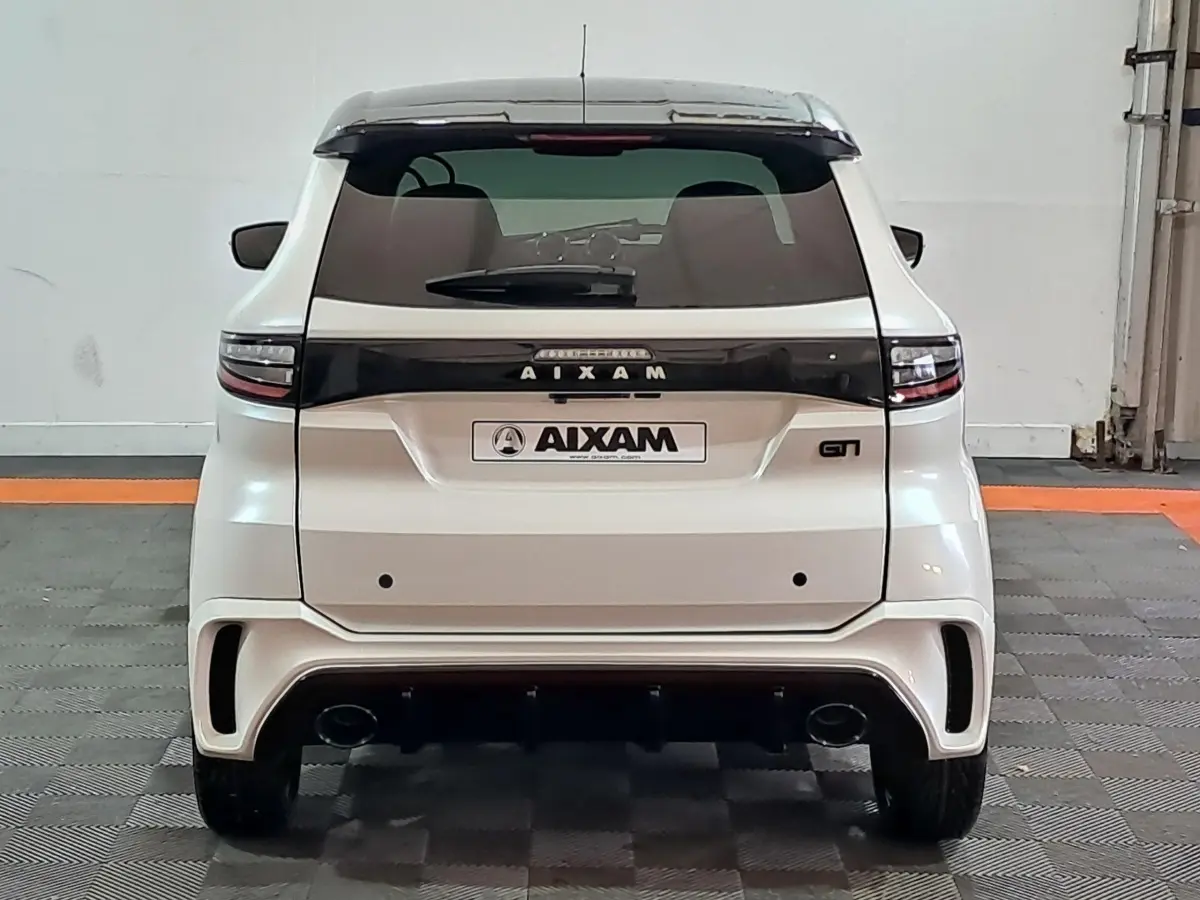 Vue arrière d'une Aixam Ambition 0.5 City Coupe GTI blanche avec bande noire et double sortie d'échappement.